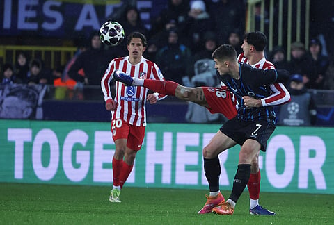 Atletico Madrid's Marc Pubill, right, and Brugge's Nicolo Tresoldi challenge for the ball during the Champions League play-off first leg soccer match between Club Brugge and Atletico Madrid, in Bruges, Belgium.