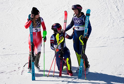 United States' Mikaela Shiffrin, center, winner of an alpine ski, women's slalom race, celebrates with second-placed Switzerland's Camille Rast, left, and third-placed Sweden's Anna Swenn Larsson, at the 2026 Winter Olympics, in Cortina d'Ampezzo, Italy.