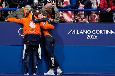 Silver medalist Melle van 't Wout of the Netherlands and bronze medalist Jens van 't Wout of the Netherlands greet supporters in the stands after the short track speed skating men's 500m final at the 2026 Winter Olympics, in Milan, Italy.