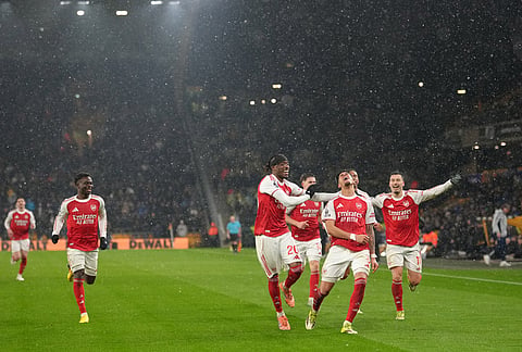 Arsenal's Piero Hincapie celebrates with teammates after scoring his side the second goal during the Premier League soccer match between Wolverhampton Wanderers and Arsenal in Wolverhampton, England.