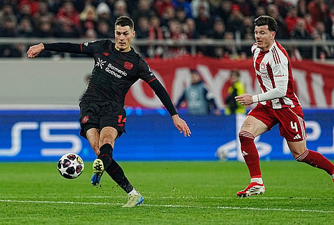 Leverkusen's Patrik Schick, left, scores against Olympiacos during a Champions League playoff soccer match between Olympiacos and Bayer 04 Leverkusen in Piraeus port, near Athens.