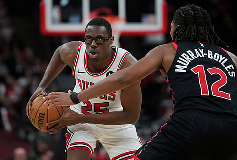 Chicago Bulls forward Jalen Smith (25) handles the ball as Toronto Raptors forward Collin Murray-Boyles (12) defends during the first half of an NBA basketball game in Chicago. 