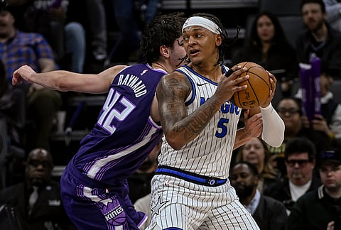 Orlando Magic forward Paolo Banchero (5) works the ball past Sacramento Kings center Maxime Raynaud (42) during the second half of an NBA basketball game in Sacramento, California.