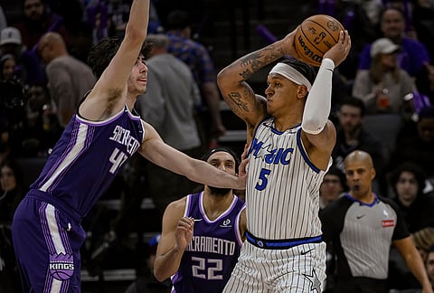 Orlando Magic forward Paolo Banchero (5) works the ball past Sacramento Kings center Maxime Raynaud (42) during the second half of an NBA basketball game in Sacramento, California.