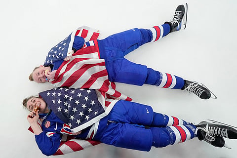 United States' Grace Zumwinkle, right, and Taylor Heise celebrate after victory ceremony for women's ice hockey at the 2026 Winter Olympics, in Milan, Italy.