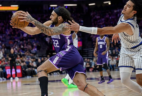 Sacramento Kings guard Devin Carter, left, drives past Orlando Magic guard Anthony Black during the second half of an NBA basketball game in Sacramento, California.