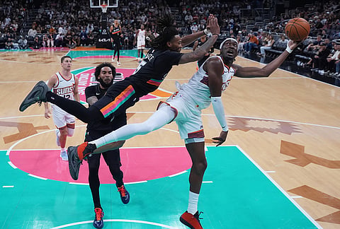 Phoenix Suns center Mark Williams, right, tries to shoot past San Antonio Spurs guard Stephon Castle (5) during the first half of an NBA basketball game in Austin, Texas.