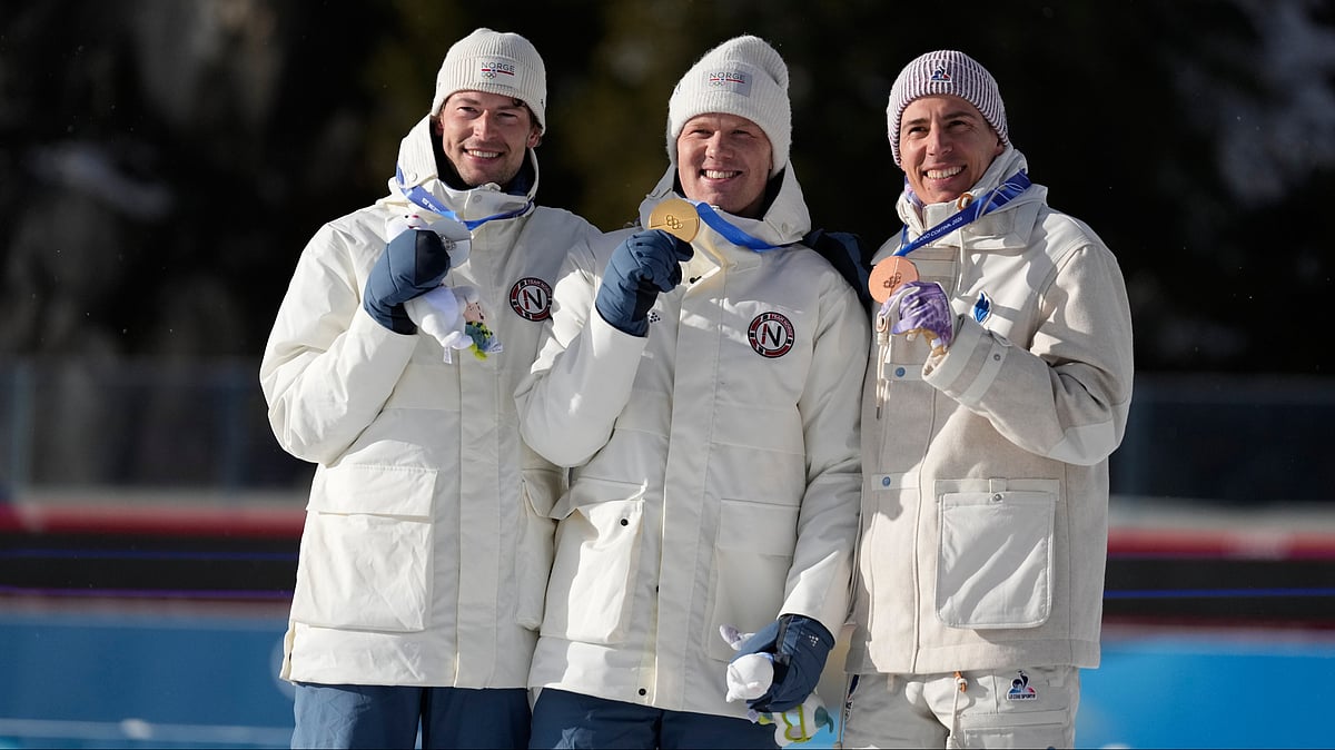| Photo: AP/Mosa'ab Elshamy : Silver medalist Sturla Holm Laegreid, of Norway, from left, gold medalist Johannes Dale-Skjevdal, of Norway, and bronze medalist Quentin Fillon Maillet, of France, pose for photos during a victory ceremony for the men's 15-kilometer mass start biathlon race at the 2026 Winter Olympics in Anterselva, Italy, Friday, Feb. 20, 2026. 
