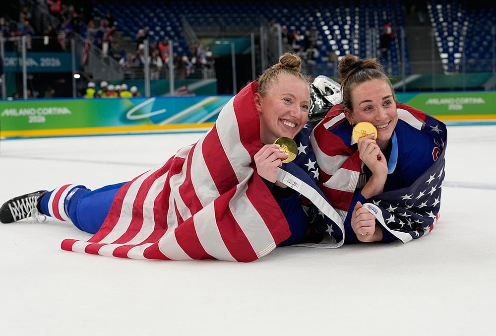 | Photo: AP/Hassan Ammar : United States' Grace Zumwinkle, left, and Taylor Heise celebrate after victory ceremony for women's ice hockey at the 2026 Winter Olympics, in Milan, Italy.