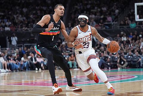 Phoenix Suns guard Jordan Goodwin (23) drives against San Antonio Spurs forward Victor Wembanyama (1) during the first half of an NBA basketball game in Austin, Texas.