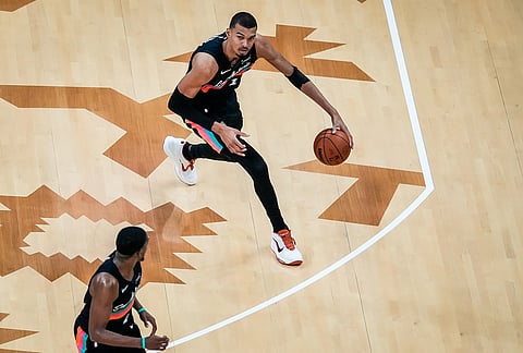 San Antonio Spurs forward Victor Wembanyama (1) looks to pass to guard De'aaron Fox (4) in the third quarter of an NBA basketball game against the Phoenix Suns in Austin, Texas.