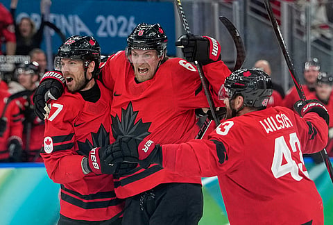 Canada's Shea Theodore (27) celebrates with teammates after scoring his side's second goal during a men's ice hockey semifinal game between Canada and Finland at the 2026 Winter Olympics, in Milan, Italy.