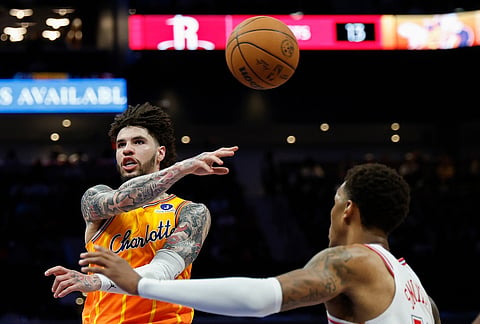 Charlotte Hornets guard LaMelo Ball, left, passes past Houston Rockets forward Jabari Smith Jr. during the second half of an NBA basketball game in Charlotte, North Carolina.