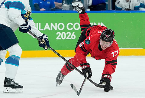 Finland's Esa Lindell (23) challenges for the puck with Canada's Macklin Celebrini (17) during a men's ice hockey semifinal game between Canada and Finland at the 2026 Winter Olympics, in Milan, Italy.