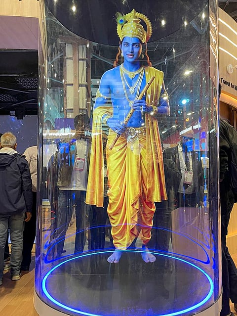 An AI-generated image of Lord Krishna is displayed through holographic projection inside a transparent cylindrical capsule at the 'Jio Intelligence' pavilion of Reliance Industries, during the AI Impact Summit, in New Delhi. The image is drawn from "Mahabharat: Ek Dharmayudh" series, which is fully generated by AI. 