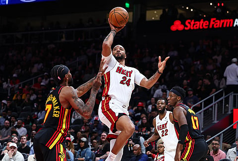 Miami Heat guard Norman Powell (24) goes up to shoot against Atlanta Hawks guard Nickeil Alexander-Walker, left, during the second half of an NBA basketball game, in Atlanta.