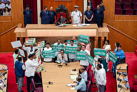 Opposition MLAs from the BJD and Congress shout slogans in the Well of the Odisha Legislative Assembly during Question Hour, protesting alleged irregularities and mismanagement in farmers' paddy procurement by the BJP government, in Bhubaneswar.
