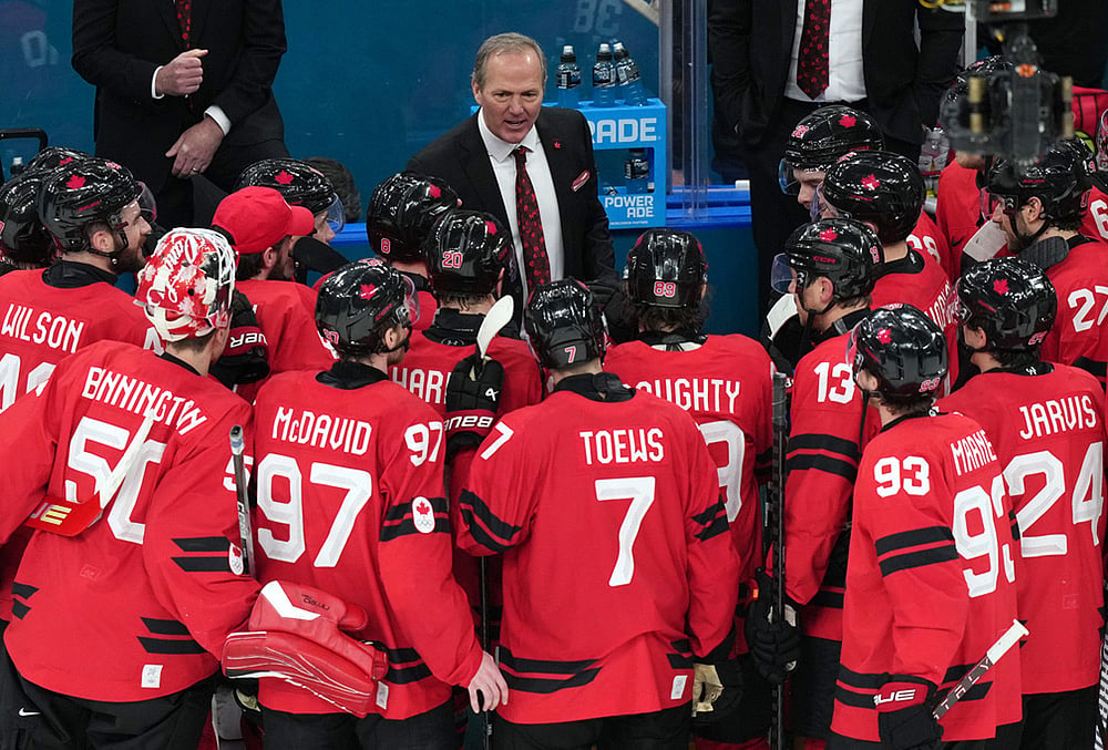 | Photo: AP/Carolyn Kaster : Canada head coach Jon Cooper talks with his players after their win against Finland in a men's ice hockey semifinal game at the 2026 Winter Olympics in Milan, Italy.