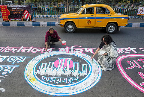 Artists paint graffiti murals celebrating linguistic diversity on the eve of International Mother Language Day, near the Academy of Fine Arts, in Kolkata.