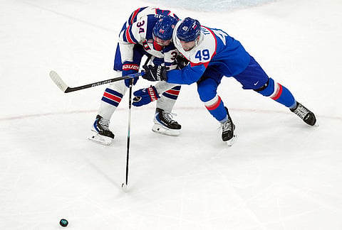 United States' Auston Matthews (34) and Slovakia's Samuel Takac (49) chase after the puck during the second period of a men's ice hockey semifinal game at the 2026 Winter Olympics in Milan, Italy.