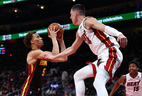 Atlanta Hawks guard Dyson Daniels (5) shoots against Miami Heat guard Tyler Herro, right, during the first half of an NBA basketball game, in Atlanta.