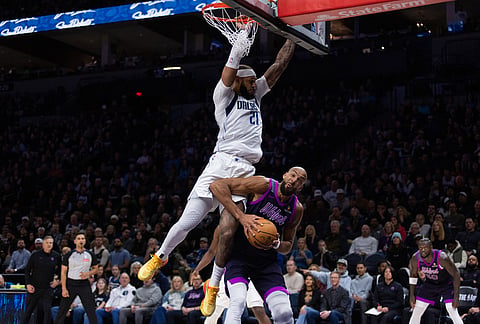 Dallas Mavericks' Daniel Gafford (21) goes against Rudy Gobert (27) at the basket during the first half of an NBA basketball game in Minneapolis.