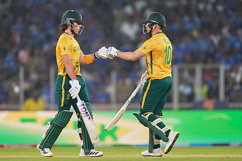 South Africa's Dewald Brevis, left, and batting partner David Miller touch gloves during the T20 World Cup cricket match between India and South Africa in Ahmedabad, India.