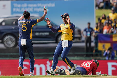 Sri Lanka's captain Dasun Shanaka, center, and Dushmantha Chameera, left, celebrate the runout of England's Tom Banton, right, during the T20 World Cup cricket match between Sri Lanka and England in Pallekele, Sri Lanka.