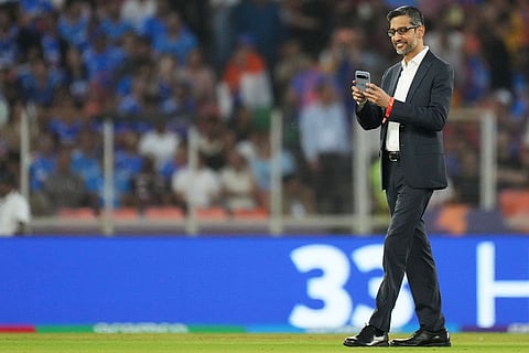 Google CEO Sundar Pichai uses his mobile phone as he is shown around the playing field before the start of the T20 World Cup cricket match between India and South Africa in Ahmedabad, India.