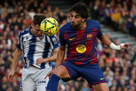 Levante's Jon Ander Olasagasti, left, and Barcelona's Gavi jump for the ball during a La Liga soccer match between Barcelona and Levante in Barcelona, Spain.