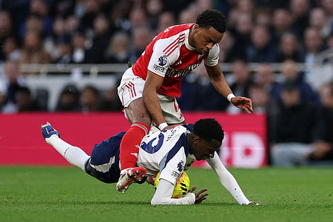 Tottenham's Pape Matar Sarr and Arsenal's Jurrien Timber challenge for the ball during the English Premier League soccer match between Tottenham Hotspur and Arsenal in London.