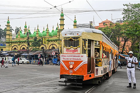 A traffic police personnel signals as tram no. 498 'Gitanjali', a wooden tram built during World War II, runs during a special heritage ride to mark the 153rd anniversary of the Calcutta tram service, in Kolkata.