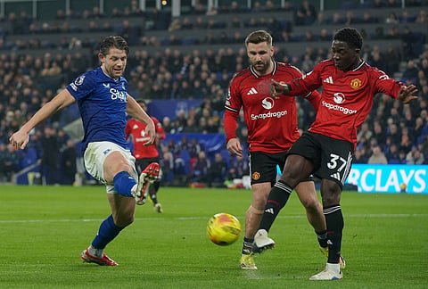 Manchester United's Mason Mount passes the bal lby Everton's James Tarkowski during the Premier League soccer match between Manchester United and Everton in Liverpool, England.