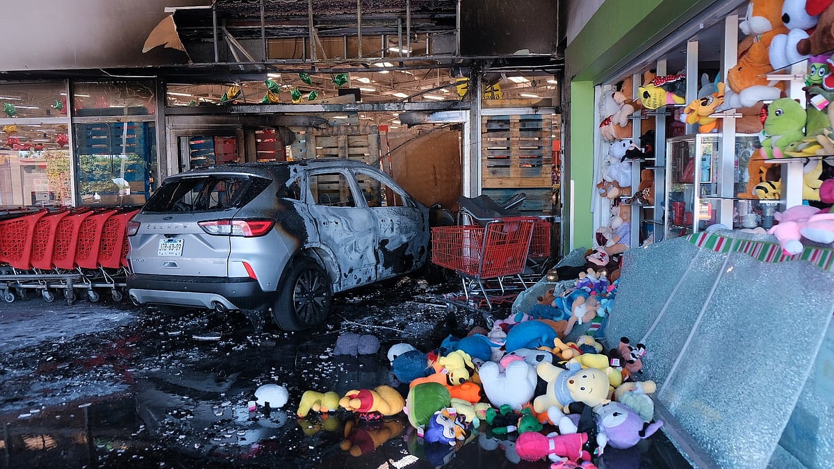 (AP Photo/Alejandra Leyva) : A charred vehicle sits at a damaged supermarket in Guadalajara, Jalisco state, Mexico, Sunday, Feb. 22, 2026, after the death of the leader of the Jalisco New Generation Cartel, Nemesio Rubén Oseguera Cervantes, known as "El Mencho." 