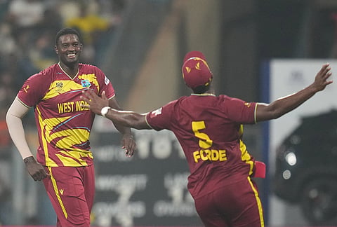West Indies' Jason Holder, left, celebrates with Matthew Forde the wicket of Zimbabwe's Graeme Cremer during the T20 World Cup cricket match between Zimbabwe and West Indies in Mumbai.