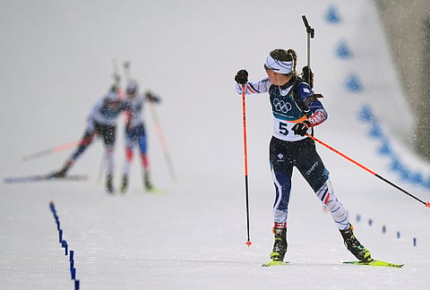 Oceane Michelon, of France, looks back as she skis to the finish line to win gold in the women's 12.5-kilometer mass start biathlon race at the 2026 Winter Olympics in Anterselva, Italy, Saturday, Feb. 21, 2026. 