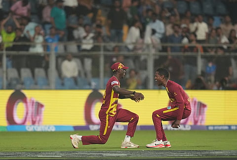 West Indies' Akeal Hosein, right, celebrates with teammates the wicket of Zimbabwe's Blessing Muzarabani during the T20 World Cup cricket match between Zimbabwe and West Indies in Mumbai.