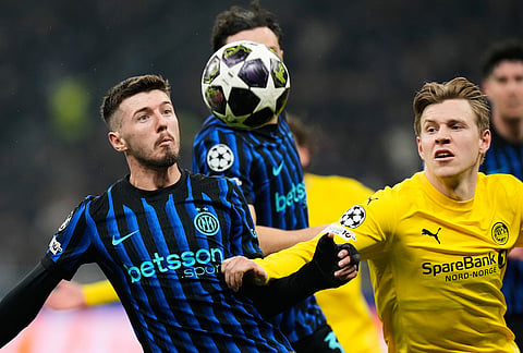 Inter Milan's Petar Sucic, left, vies for the ball with Glimt's Jens Petter Hauge during a Champions League playoff soccer match between Inter Milan and Bodo Glimt, at the San Siro stadium in Milan, Italy.
