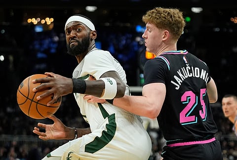 Milwaukee Bucks' Bobby Portis, left, drives to the basket against Miami Heat's Kasparas Jakučionis during the first half of an NBA basketball game in Milwaukee.