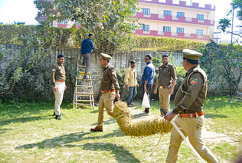 Police personnel and forest officials set up a trap after a leopard was spotted inside the premises of Green Field Public School Govindpuram, in Ghaziabad.