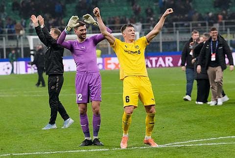 Glimt's Jostein Gundersen, right, and Glimt's goalkeeper Nikita Haikin celebrate at the end of the Champions League playoff soccer match between Inter Milan and Bodo Glimt, at the San Siro stadium in Milan, Italy.