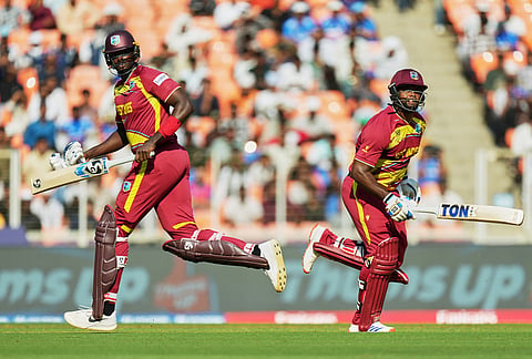 West Indies' Jason Holder, left, and batting partner Romario Shepherd run between the wickets during the T20 World Cup cricket match between South Africa and West Indies in Ahmedabad.