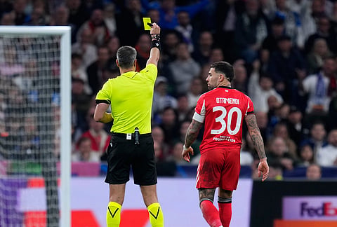 Referee Slavko Vincic shows a yellow card to Benfica's Nicolas Otamendi during the second leg of the Champions League playoff soccer match between Real Madrid and Benfica in Madrid, Spain.
