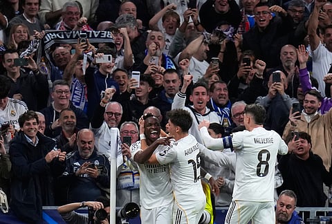 Real Madrid's Vinicius Junior, left, celebrates with teammates after scoring his side's second goal during the second leg of the Champions League playoff soccer match between Real Madrid and Benfica in Madrid, Spain.