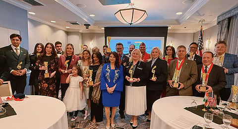 Arun Kar and Nidhi Kar holding awards at formal ceremony in New York with honorees