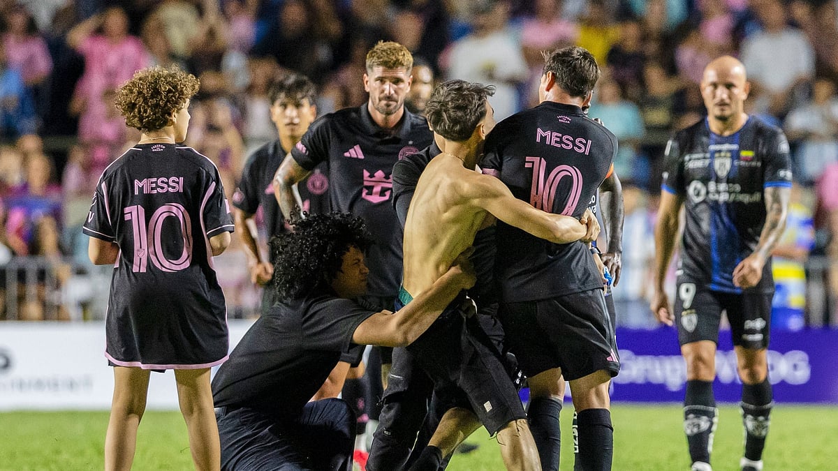 (AP Photo/Alejandro Granadillo) : A fan who got onto the field grabs Inter Miami's Lionel Messi at the end of an international friendly soccer match against Ecuador's Independiente del Valle in Bayamon, Puerto Rico, Thursday, Feb. 26, 2026.