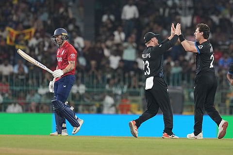 New Zealand's Matt Henry, right, celebrates with Glenn Phillips, left, the wicket of England's Phil Salt, extreme left, walks during the T20 World Cup cricket match between England and New Zealand in Colombo, Sri Lanka.