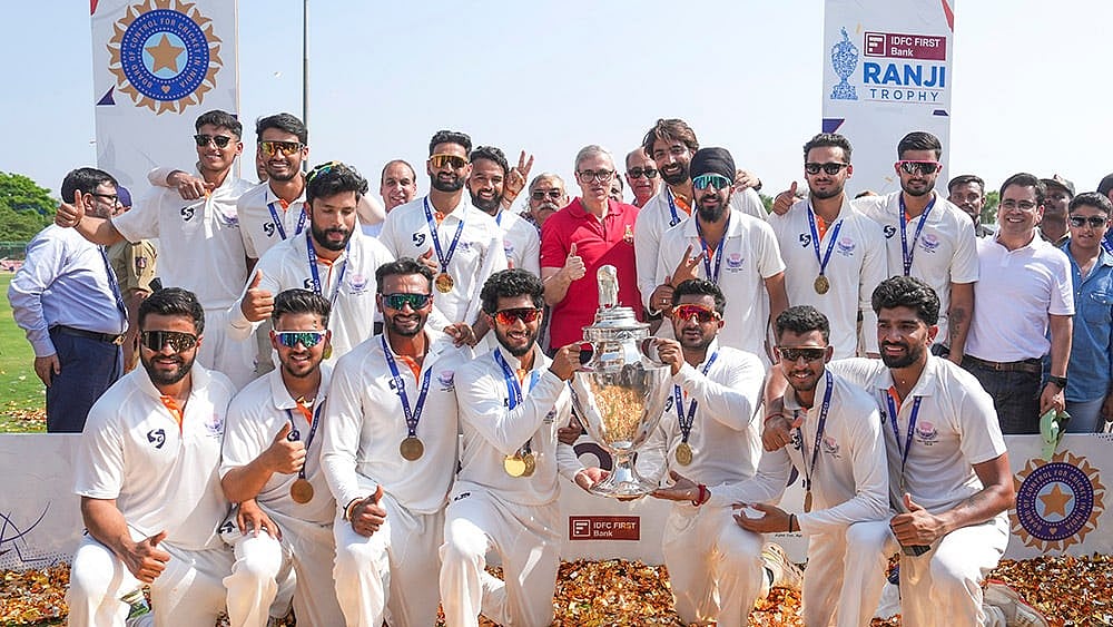 | Photo: PTI/Shailendra Bhojak : Jammu and Kashmir Chief Minister Omar Abdullah poses with players during the felicitation ceremony after the team's victory in the Ranji Trophy 2025-26 final cricket match against Karnataka, at KSCA Stadium, in Hubballi, Karnataka.