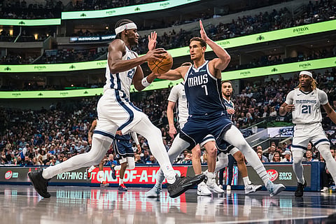 Memphis Grizzlies forward Taylor Hendricks, left, goes to the basket as Dallas Mavericks forward Dwight Powell (7) defends during an NBA basketball game in Dallas.