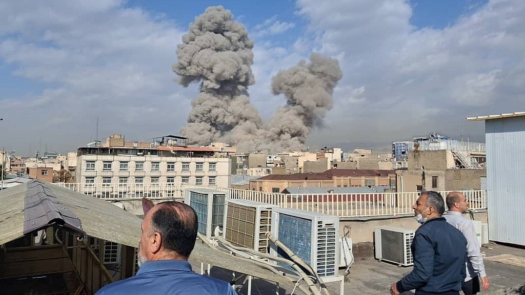 AP : People watch as smoke rises on the skyline after an explosion in Tehran, Iran.